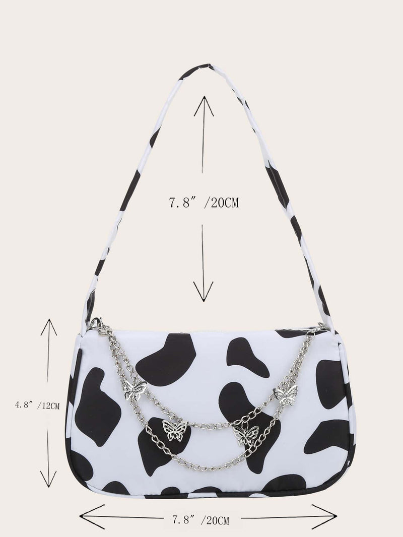 Bolso de hombro con dije de mariposa y estampado de vaca