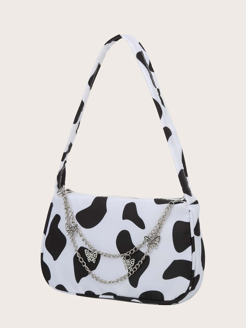 Bolso de hombro con dije de mariposa y estampado de vaca