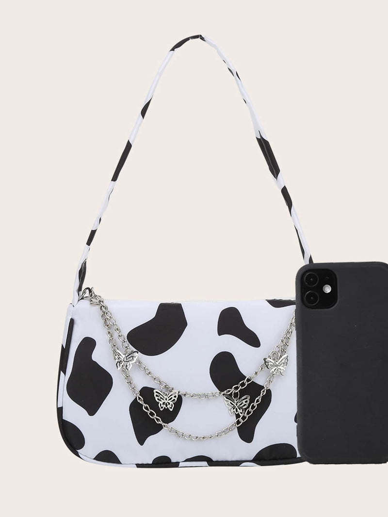 Bolso de hombro con dije de mariposa y estampado de vaca